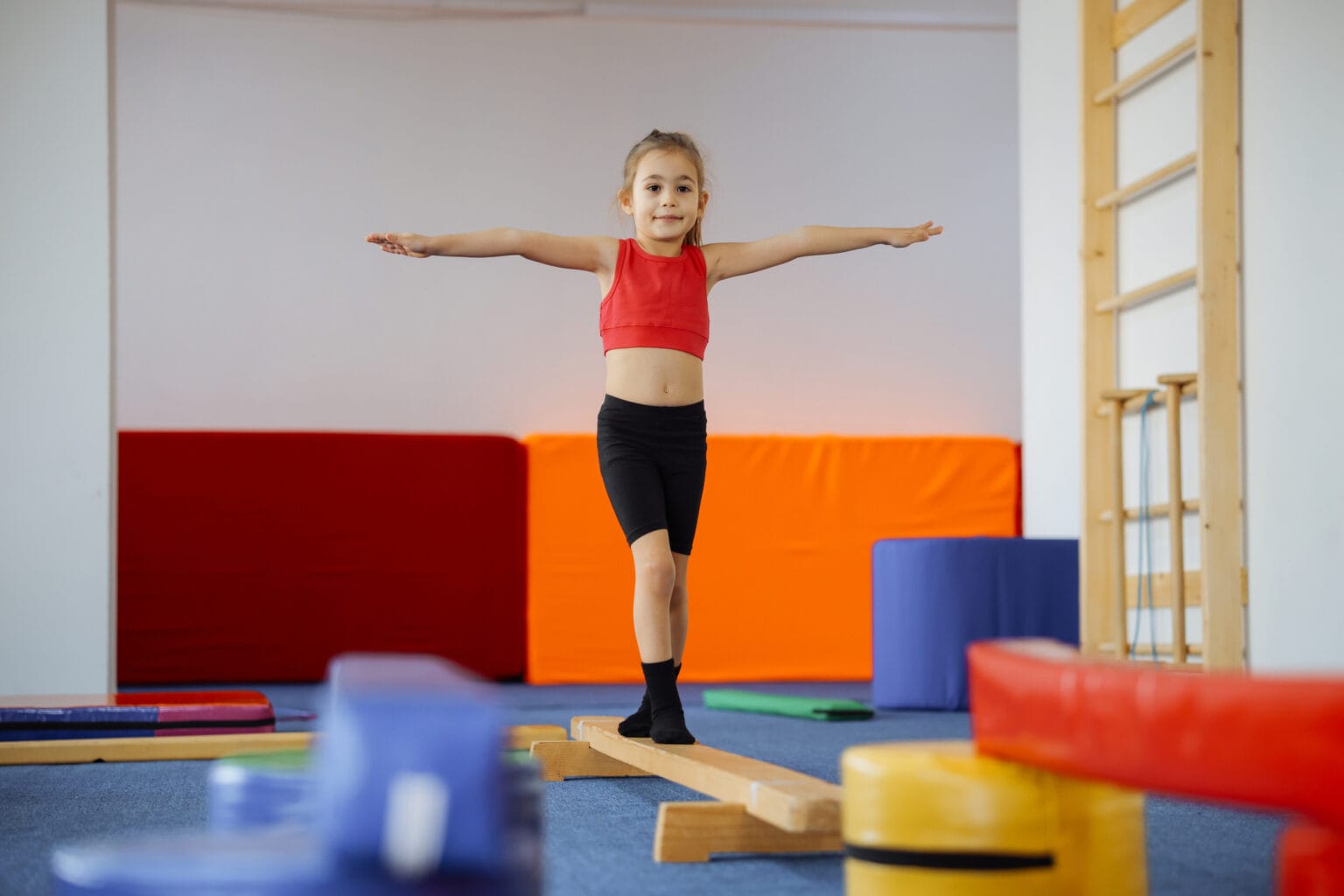 Cute active child girl in sensory integration room, kindergarten. Kid is active leisure. Childhood and sporty lifestyle.Sports weekend in gymnastic center. Fitness,healthy, develop skills concept