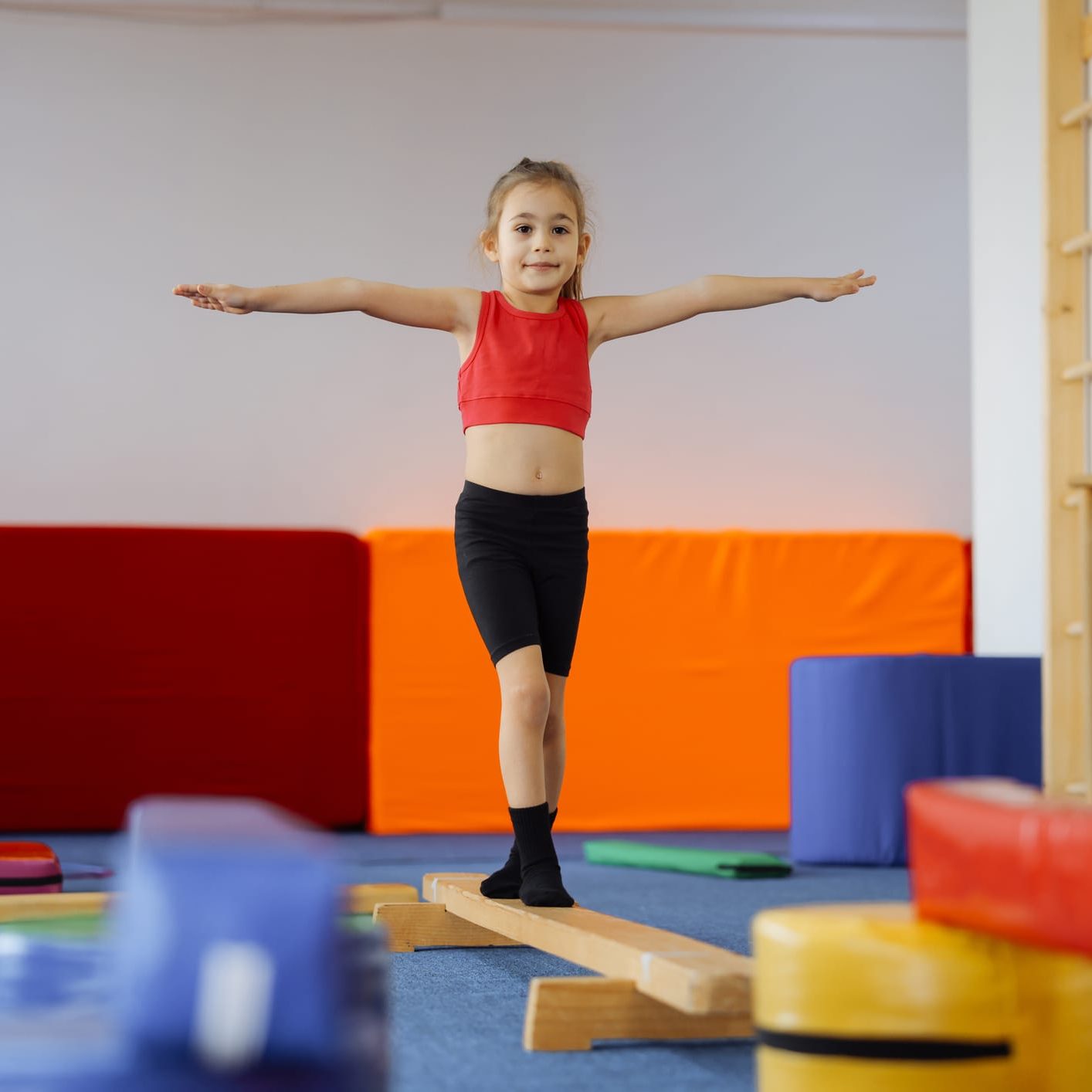 Cute active child girl in sensory integration room, kindergarten. Kid is active leisure. Childhood and sporty lifestyle.Sports weekend in gymnastic center. Fitness,healthy, develop skills concept